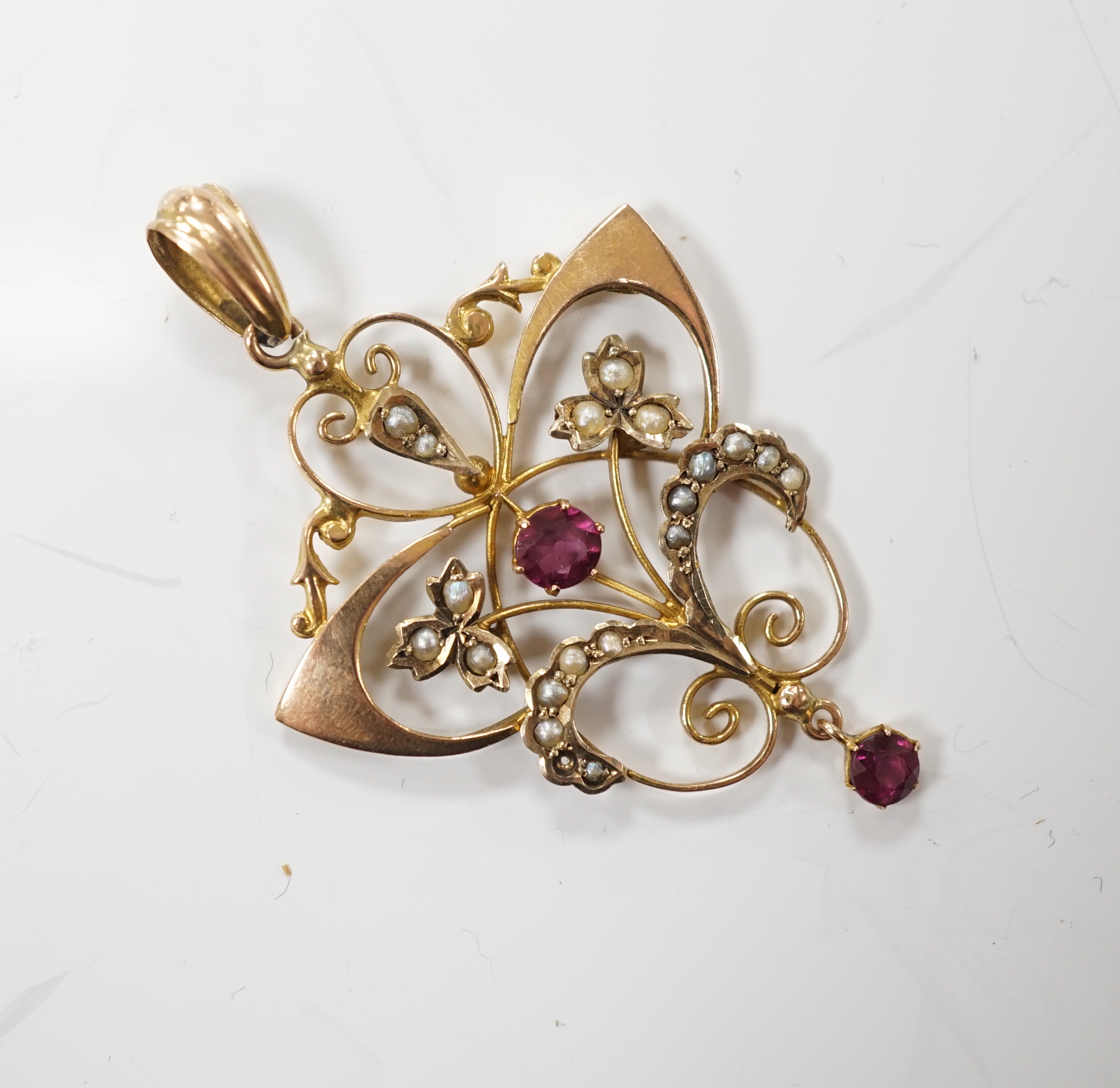An Edwardian 9ct, garnet and seed pearl cluster set drop pendant, overall 47mm, gross weight 2.8 grams.